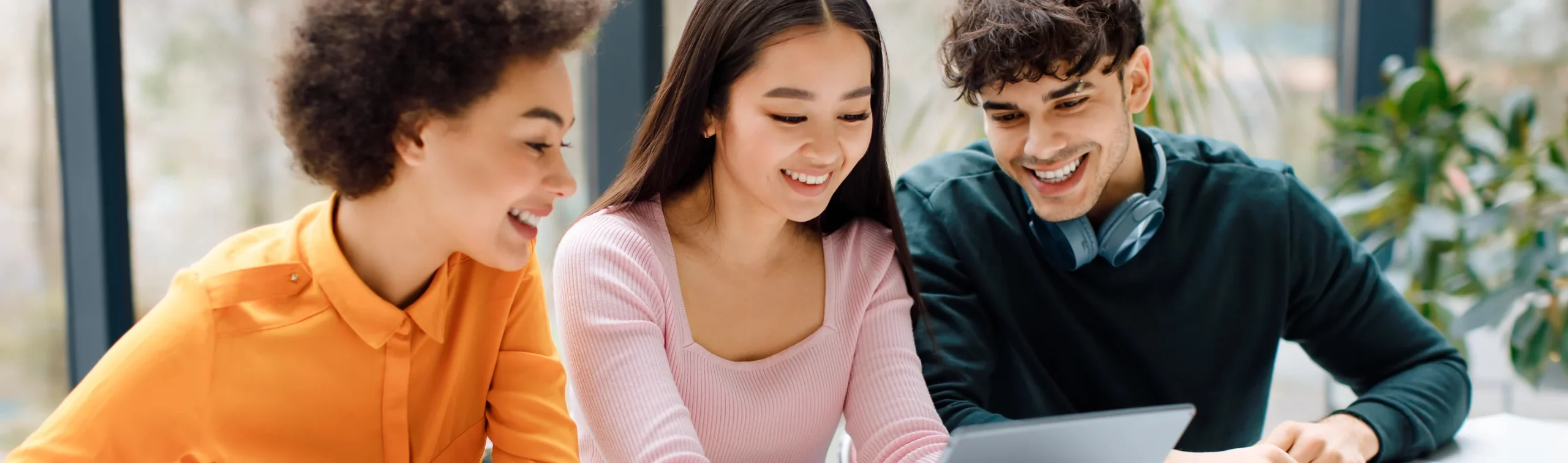 Happy students studying together around laptops in a collaborative learning environment